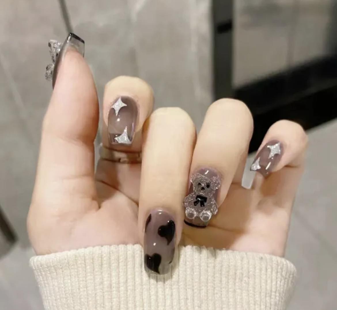 Medium Length Squoval Press on Nails. Clear Grey with Black Hearts, Glitter Stars & Teddy Bears. Durable Acrylic Press on Nails. Easy and quick to apply. Great for those special occasions, parties or add an edge to any outfit. Gorgeous, flattering and you can re-use them again and again.