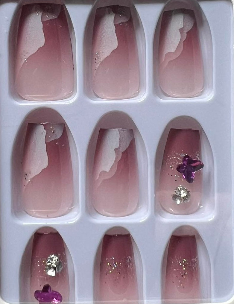 Shorter Length Coffin Press on Nails. Mauve with White Clouds, Purple Butterflies & Jewels. Easy and quick to apply. Great for those special occasions, parties or add an edge to any outfit. Gorgeous, flattering and you can re-use them again and again.