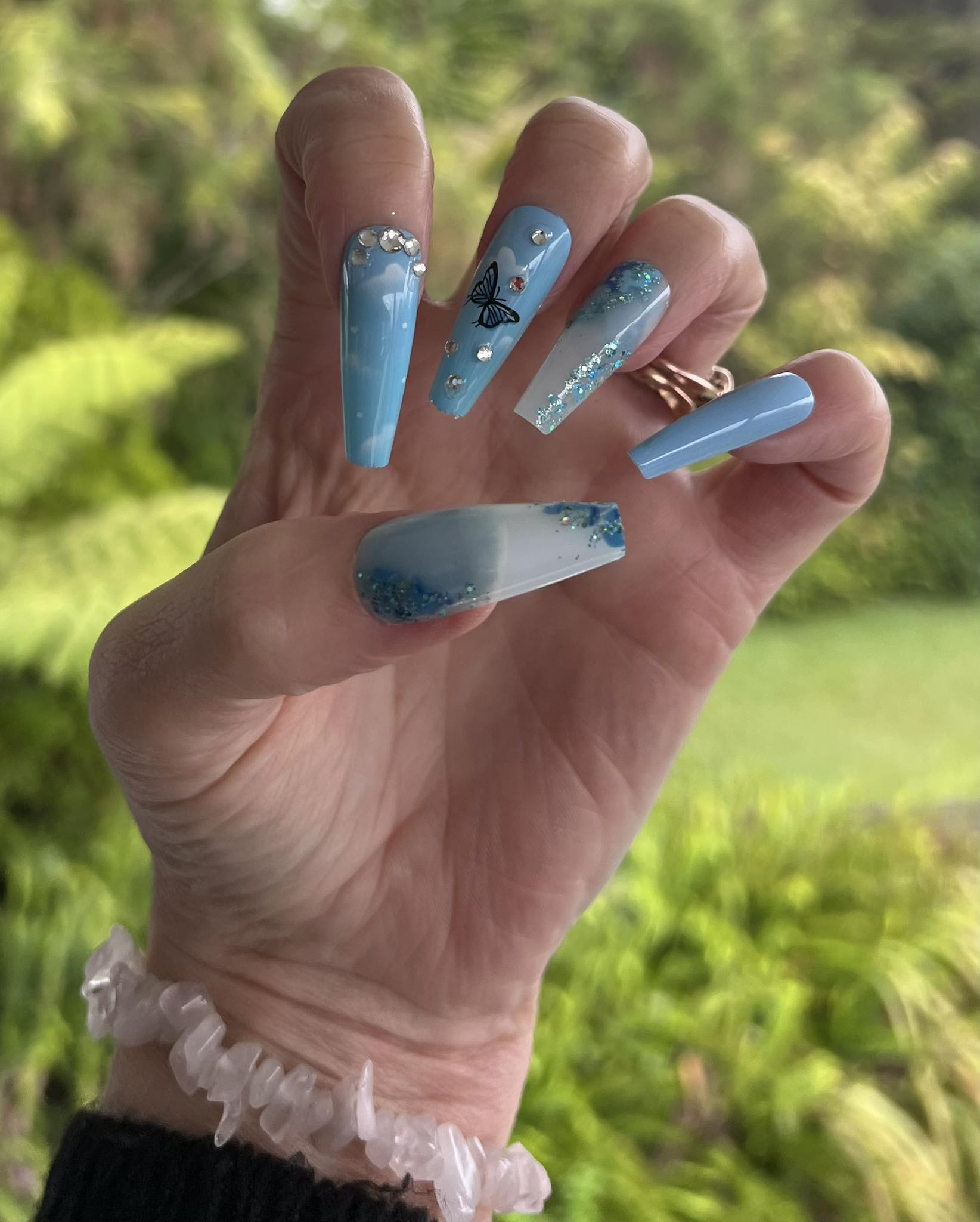 Long Coffin Press on Nails Blue with Clouds, Butterflies & Jewels. Durable Acrylic Press on Nails. Easy and quick to apply. Great for those special occasions, parties or add an edge to any outfit. Gorgeous, flattering and you can re-use them again and again.